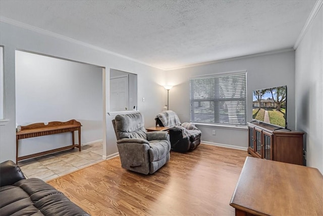 living room featuring a textured ceiling, ornamental molding, and light wood-type flooring