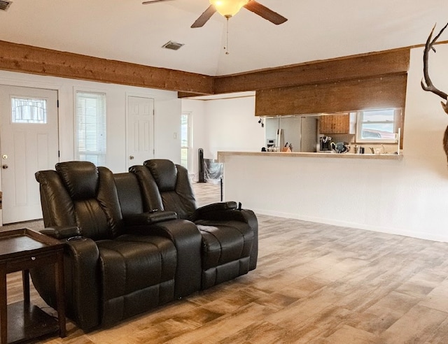 cinema room featuring light wood-type flooring and ceiling fan