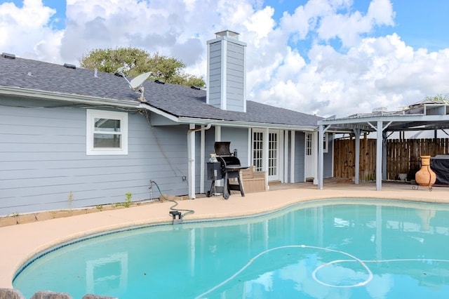 view of pool with grilling area, french doors, and a patio area