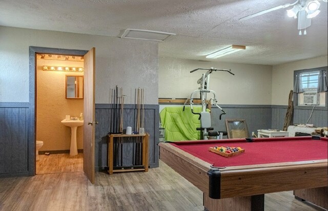 game room with wood-type flooring, a textured ceiling, cooling unit, and billiards