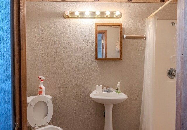 bathroom featuring walk in shower and toilet