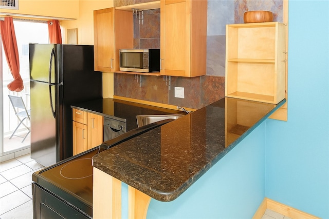 14300 S Padre Island Dr Unit 79, Corpus Christi, TX 78418 - kitchen with stainless steel microwave, freestanding refrigerator, dark stone counters, light tile patterned floors, and dishwashing machine