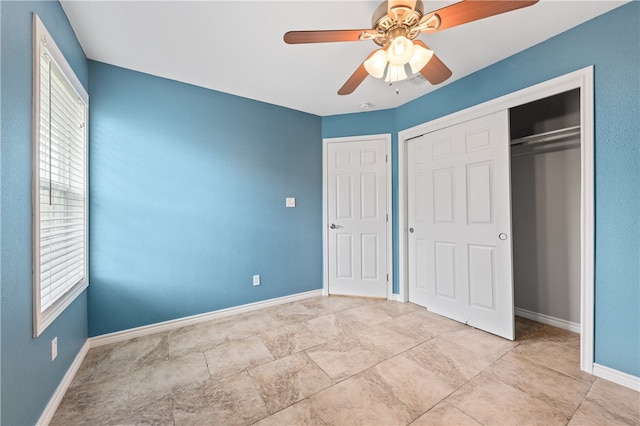 unfurnished bedroom with ceiling fan and a closet