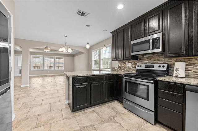 kitchen with light stone counters, kitchen peninsula, appliances with stainless steel finishes, backsplash, and decorative light fixtures