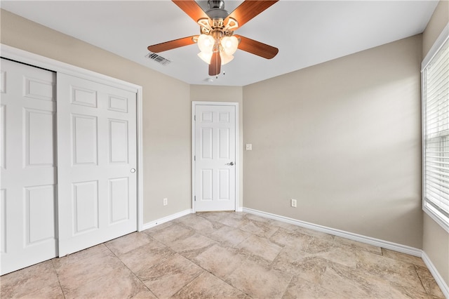 unfurnished bedroom featuring ceiling fan and a closet