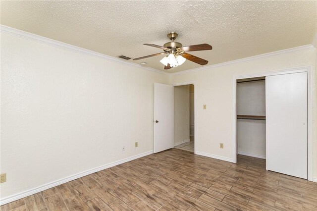 bathroom with tile patterned flooring, a textured ceiling, toilet, vanity, and ornamental molding