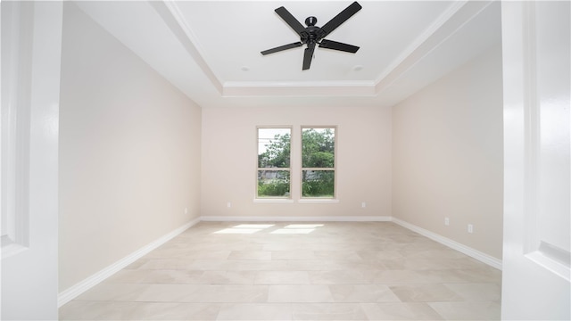 unfurnished room with ceiling fan, light tile patterned flooring, crown molding, and a tray ceiling