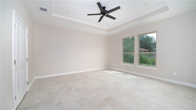 unfurnished room featuring a raised ceiling and ceiling fan