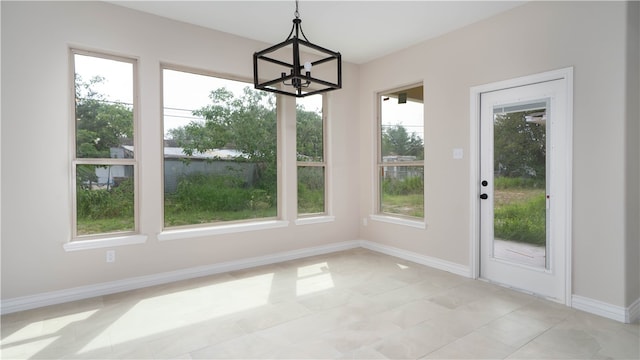 unfurnished dining area featuring a chandelier, a wealth of natural light, and light tile patterned flooring