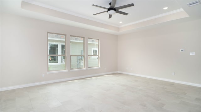 spare room with a raised ceiling, ceiling fan, and crown molding