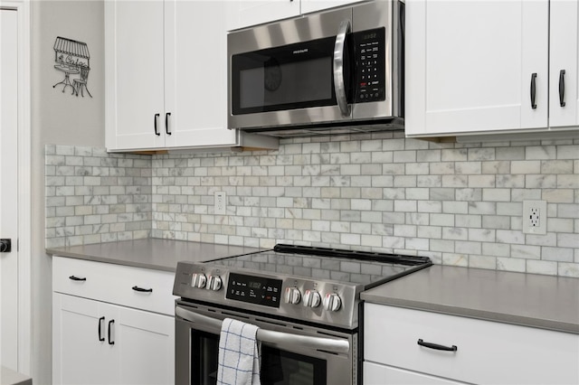 964 Allende St, Seguin, TX 78155 - kitchen with appliances with stainless steel finishes, backsplash, and white cabinetry
