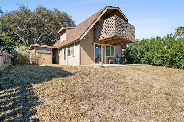 back of property with a lawn and a patio area