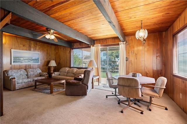 carpeted living room featuring beamed ceiling, plenty of natural light, wooden ceiling, and wooden walls