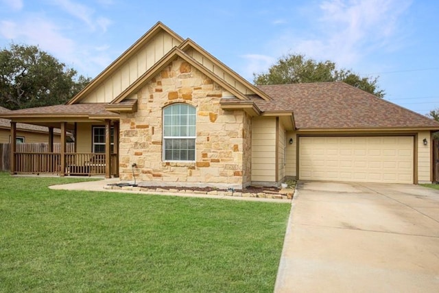 view of front of property featuring an attached garage, a shingled roof, driveway, a front lawn, and board and batten siding