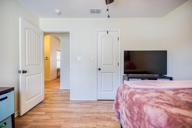 2421 Country Oaks Cir, Ingleside, TX 78362 - bedroom featuring arched walkways, baseboards, visible vents, and light wood-style floors