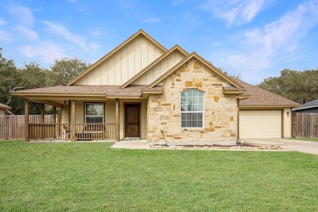 view of front of house featuring concrete driveway, covered porch, fence, a front lawn, and board and batten siding