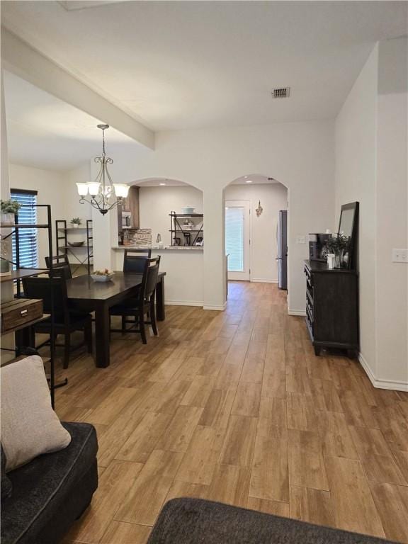 2421 Country Oaks Cir, Ingleside, TX 78362 - interior space featuring light wood finished floors, visible vents, arched walkways, and a chandelier