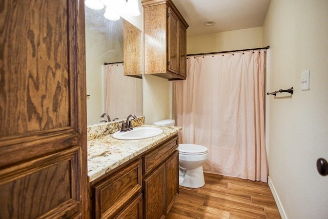 2421 Country Oaks Cir, Ingleside, TX 78362 - full bath with a shower with shower curtain, toilet, vanity, wood finished floors, and baseboards