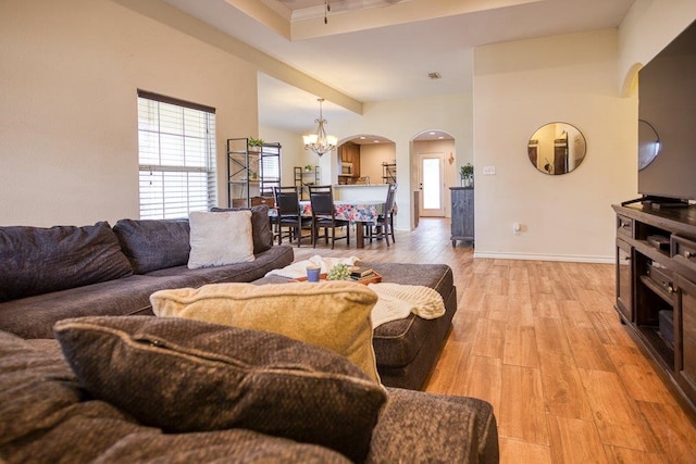 2421 Country Oaks Cir, Ingleside, TX 78362 - living area featuring arched walkways, a notable chandelier, visible vents, light wood-style flooring, and baseboards