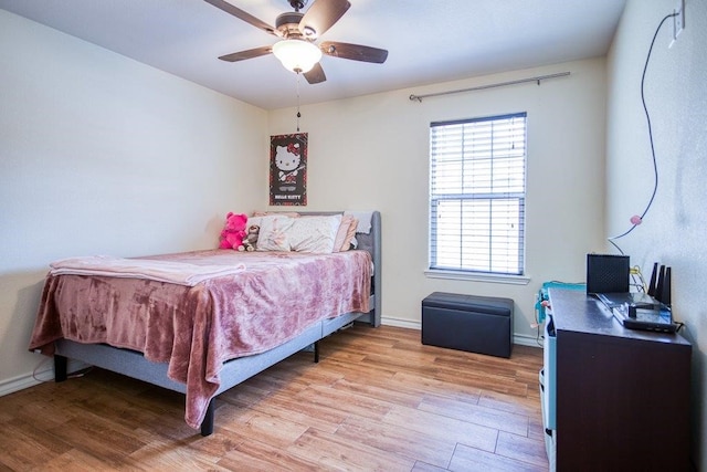 2421 Country Oaks Cir, Ingleside, TX 78362 - bedroom with light wood-style flooring, baseboards, and a ceiling fan