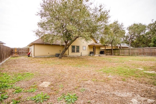 2421 Country Oaks Cir, Ingleside, TX 78362 - rear view of property featuring a fenced backyard, a yard, and central air condition unit