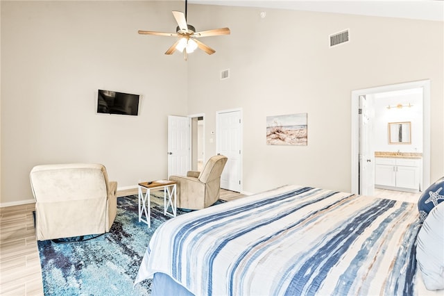 bedroom with baseboards, light wood-style floors, visible vents, and high vaulted ceiling