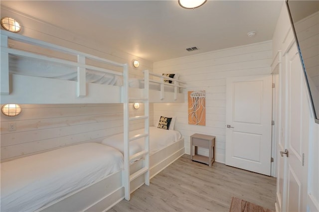 129 N Alister St Unit 2, Port Aransas, TX 78373 - bedroom featuring light wood-type flooring and wood walls