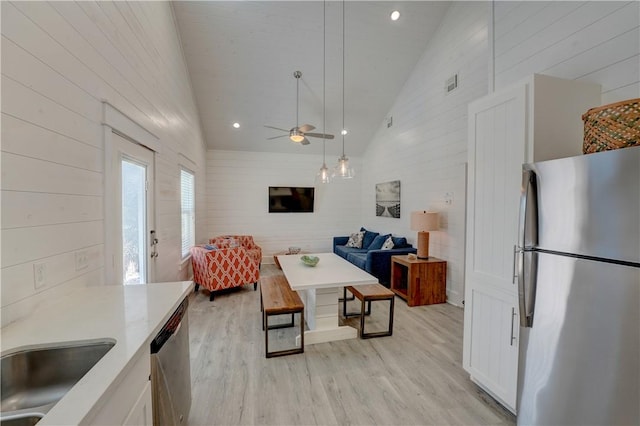 129 N Alister St Unit 2, Port Aransas, TX 78373 - living room with light wood-style flooring, ceiling fan, wood walls, and high vaulted ceiling