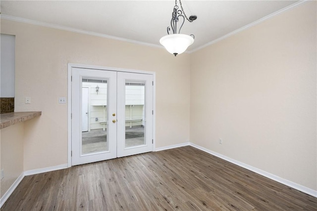 unfurnished dining area with wood-type flooring, crown molding, and french doors