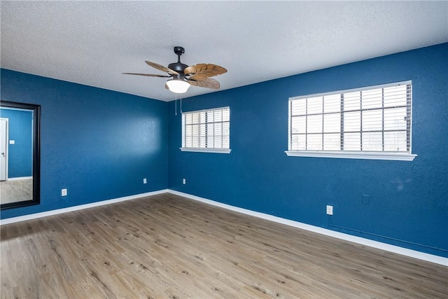 unfurnished room with hardwood / wood-style floors, ceiling fan, and a textured ceiling