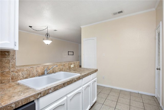 kitchen with pendant lighting, crown molding, white cabinetry, and sink