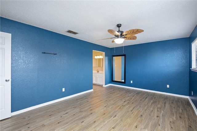 unfurnished room with ceiling fan, hardwood / wood-style floors, and a textured ceiling