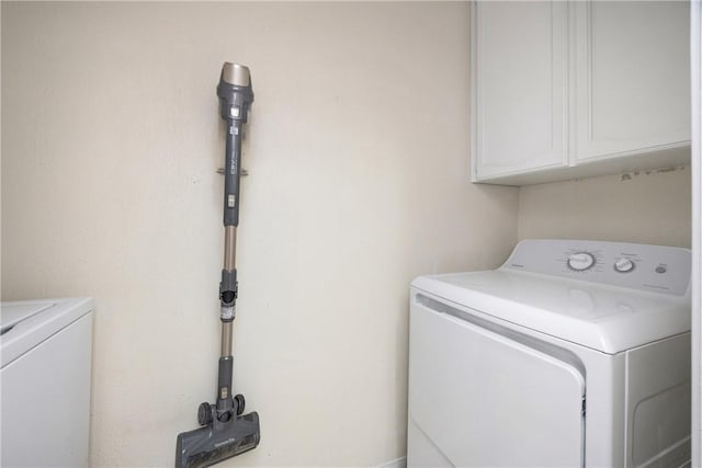 washroom featuring cabinets and washer and clothes dryer