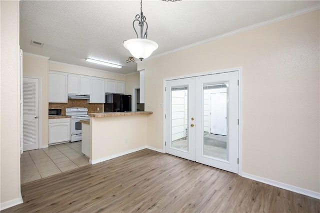 kitchen with french doors, decorative light fixtures, black refrigerator, white cabinets, and white stove