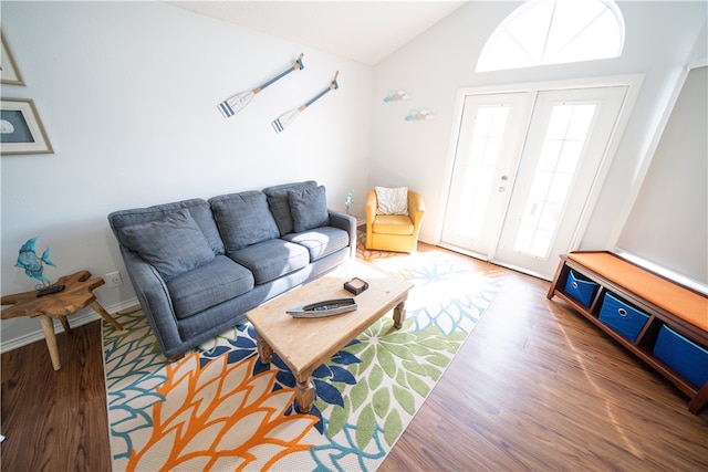 living room featuring french doors, hardwood / wood-style floors, and vaulted ceiling