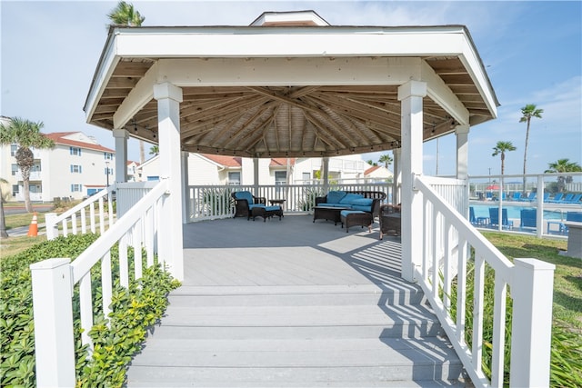 wooden terrace with a swimming pool and a gazebo