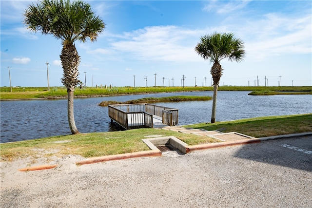 dock area with a water view and a yard