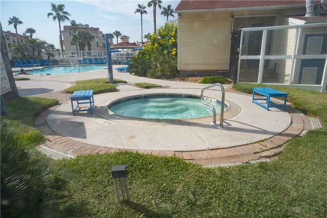 view of swimming pool with a hot tub and a patio area