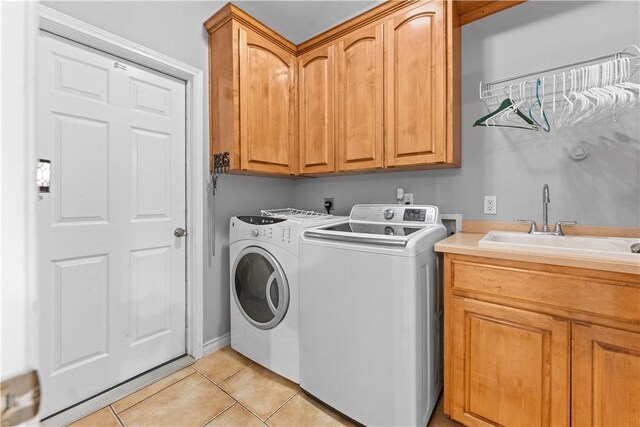 clothes washing area featuring cabinet space, independent washer and dryer, light tile patterned flooring, and a sink