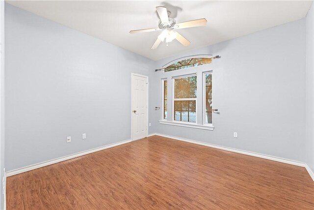 unfurnished room with baseboards, ceiling fan, and wood finished floors
