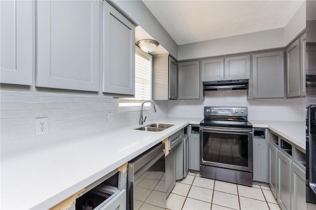 kitchen featuring under cabinet range hood, appliances with stainless steel finishes, gray cabinetry, and a sink