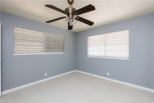 unfurnished room featuring ceiling fan and baseboards