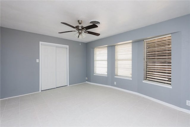 unfurnished bedroom with a ceiling fan, visible vents, baseboards, and a closet