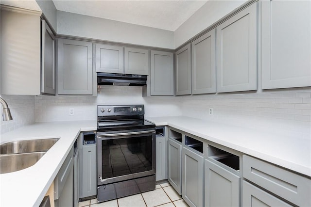 kitchen with a sink, stainless steel electric stove, under cabinet range hood, and gray cabinetry