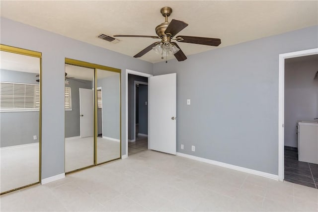 unfurnished bedroom featuring baseboards, multiple closets, visible vents, and ceiling fan