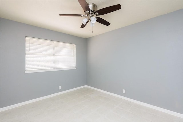 spare room featuring baseboards and a ceiling fan