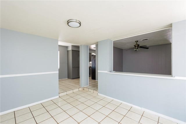 spare room featuring light tile patterned floors, baseboards, and ceiling fan