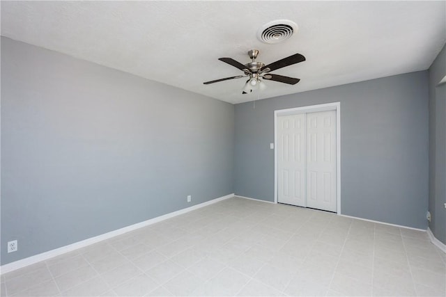 unfurnished bedroom with a closet, visible vents, a ceiling fan, and baseboards