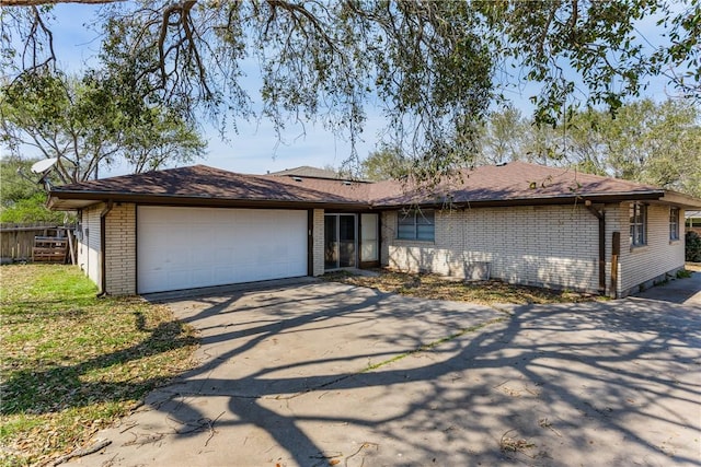 single story home featuring an attached garage, fence, brick siding, and driveway