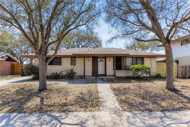 ranch-style home with brick siding and fence